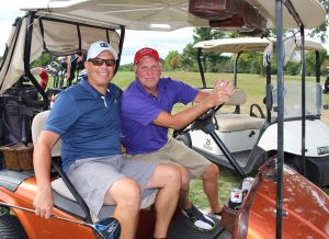 2 men on a golf cart