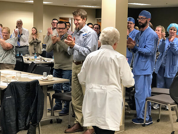 Hospital Staff applauding a lady in white uniform